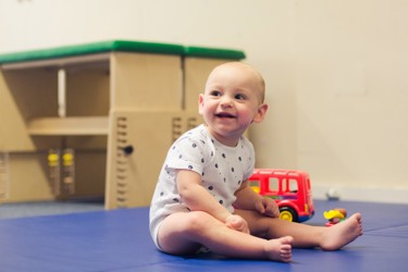 Little boy sitting on the floor smiling