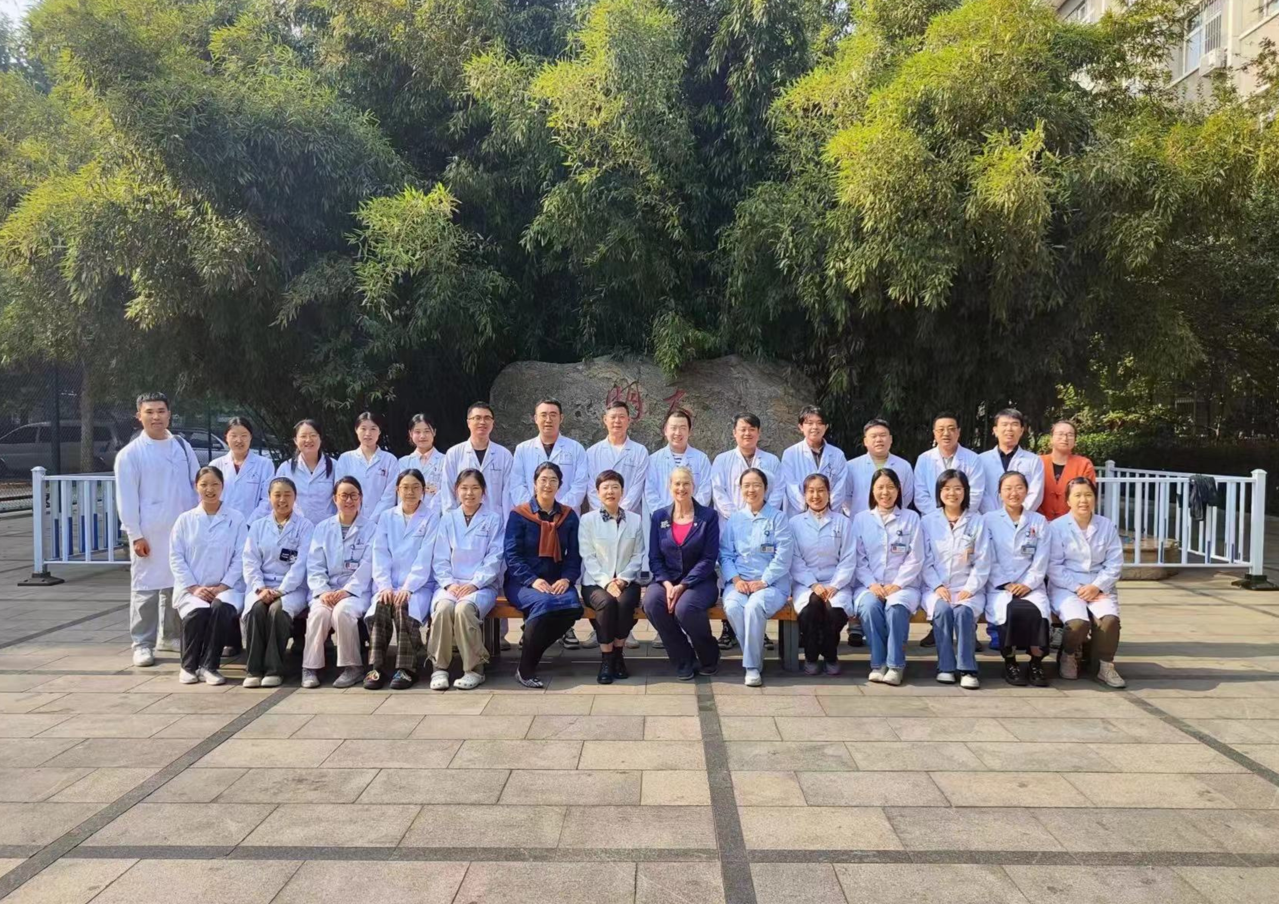 Jenny is pictured with a large group of medical professionals outside.