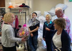 Shop volunteers being presented a gift hamper by Sharon from blue self storage.
