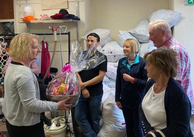 Shop volunteers being presented a gift hamper by Sharon from blue self storage.