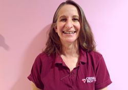 A photograph of one of our physiotherapists in front of our pink wall.