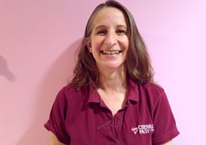 A photograph of one of our physiotherapists in front of our pink wall.