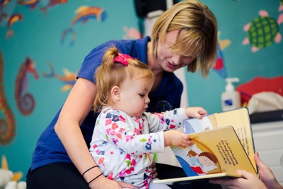 young girl and therapist reading a book