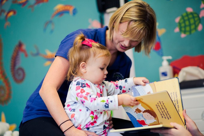 young girl and therapist reading a book