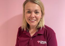 Photograph of our Clinical Specialist Physiotherapist in front of our pink wall.