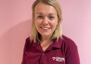 Photograph of our Clinical Specialist Physiotherapist in front of our pink wall.