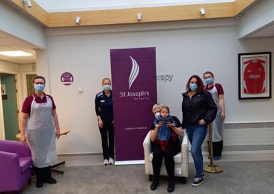 Photograph of our therapists, St Josesph's staff and a mother and child standing in St Joesph's hospital.