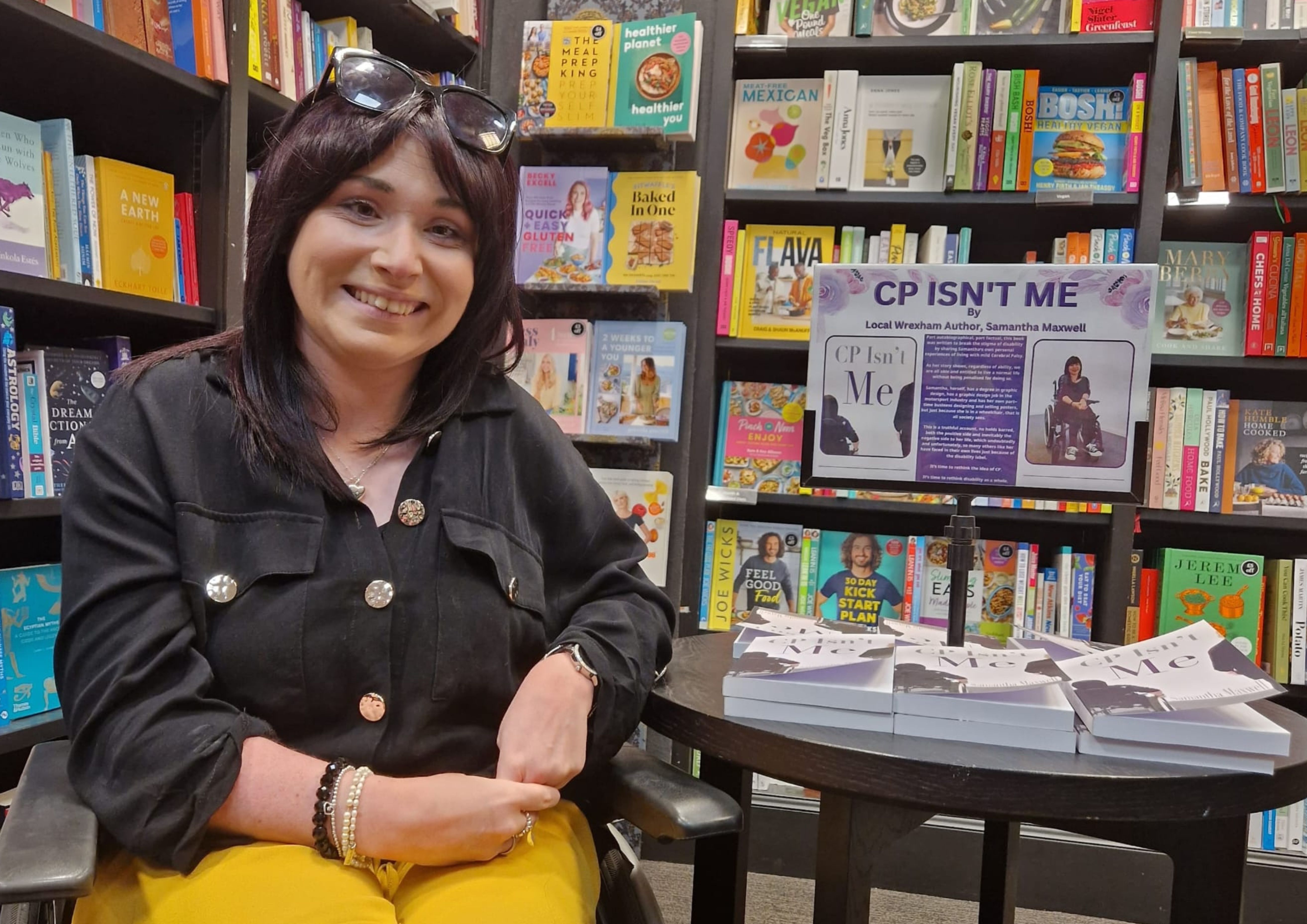 Samantha Maxwell pictured in bookshop, next to her book display.