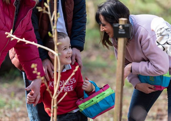 a woman smiling at a young boy