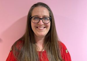 Our Head of Finance & Operations in front of our pink wall.