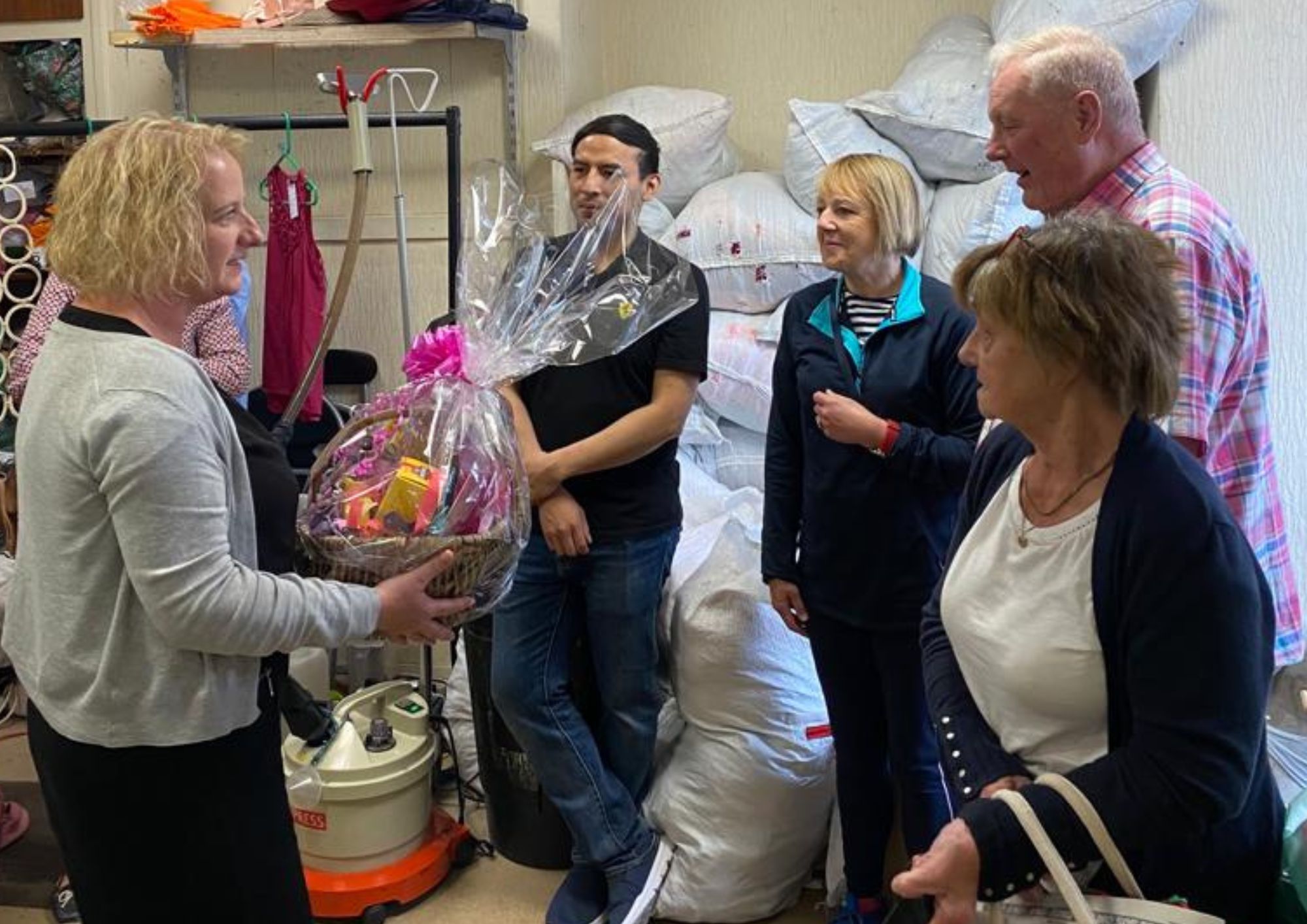 a lady presenting a hamper to a group of people