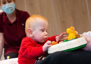 Photograph of baby boy reaching out towards a therapy toy.
