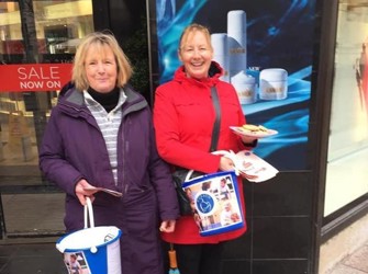 Ladies bucket collecting holding plate of cookies