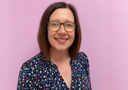 Our head of Fundraising in front of our pink wall.