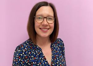 Our head of Fundraising in front of our pink wall.