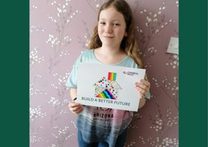Little girl holding a coloured in picture for the building appeal