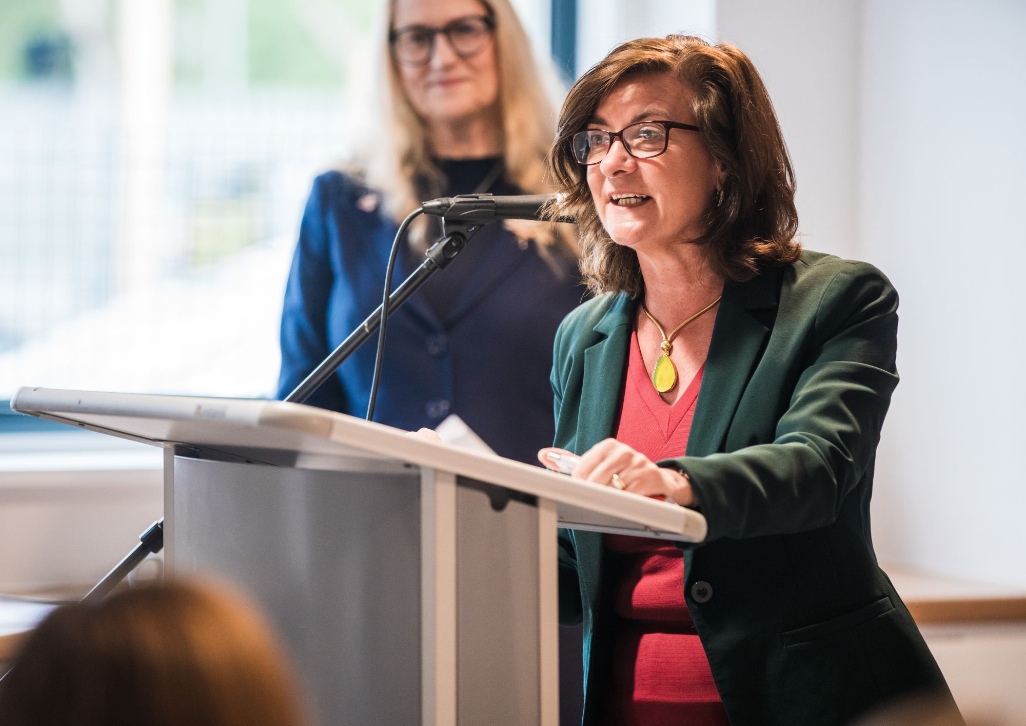 A lady stood at a podium giving a speech