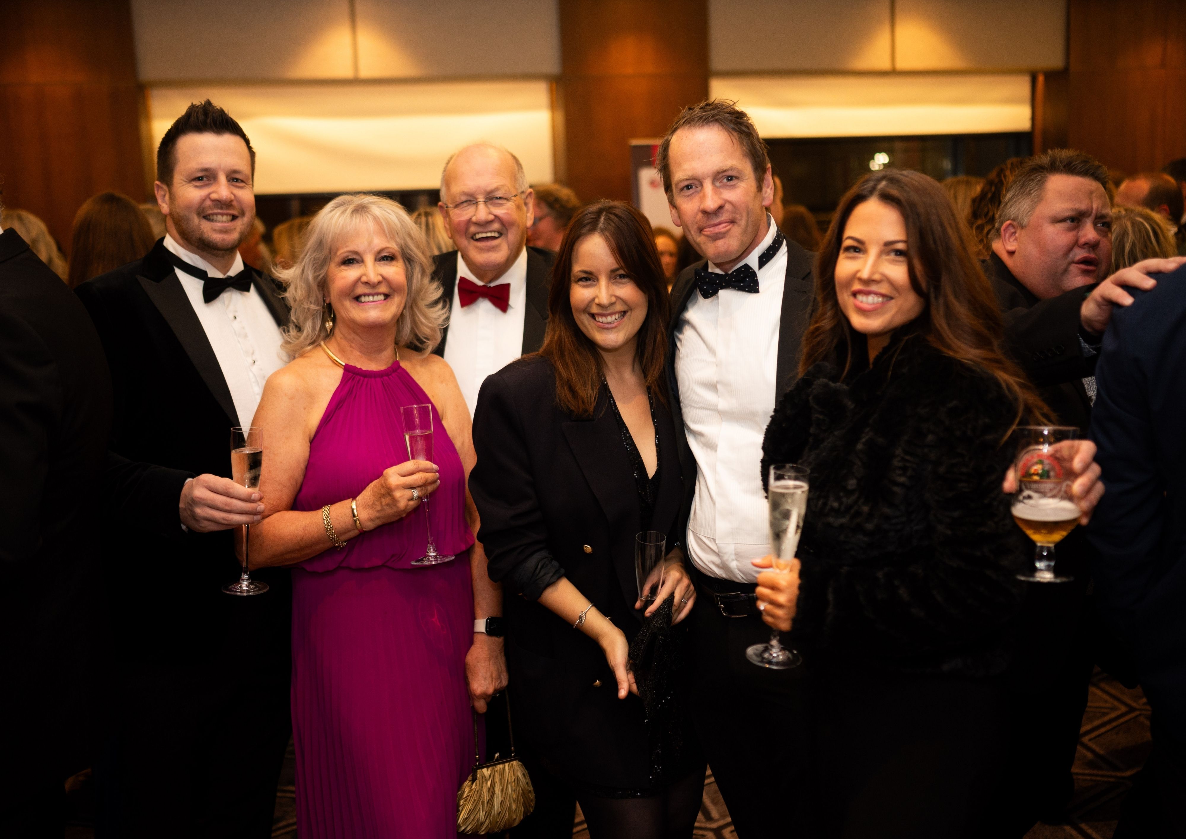 Group of men and women dressed in black tie at our Better Start Ball.