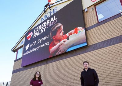 man and woman stood by advert