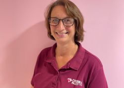 Photograph of our speech and language therapist in front of our pink wall.