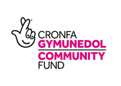 National Lottery Community Fund logo. Pink and white text reading Community Fund in English and Welsh. On the left is a fingers crossed icon with a smiley face.