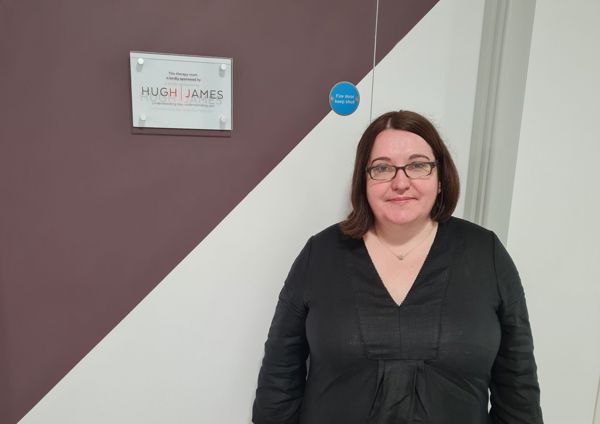 a lady standing next to a sponsorship plaque