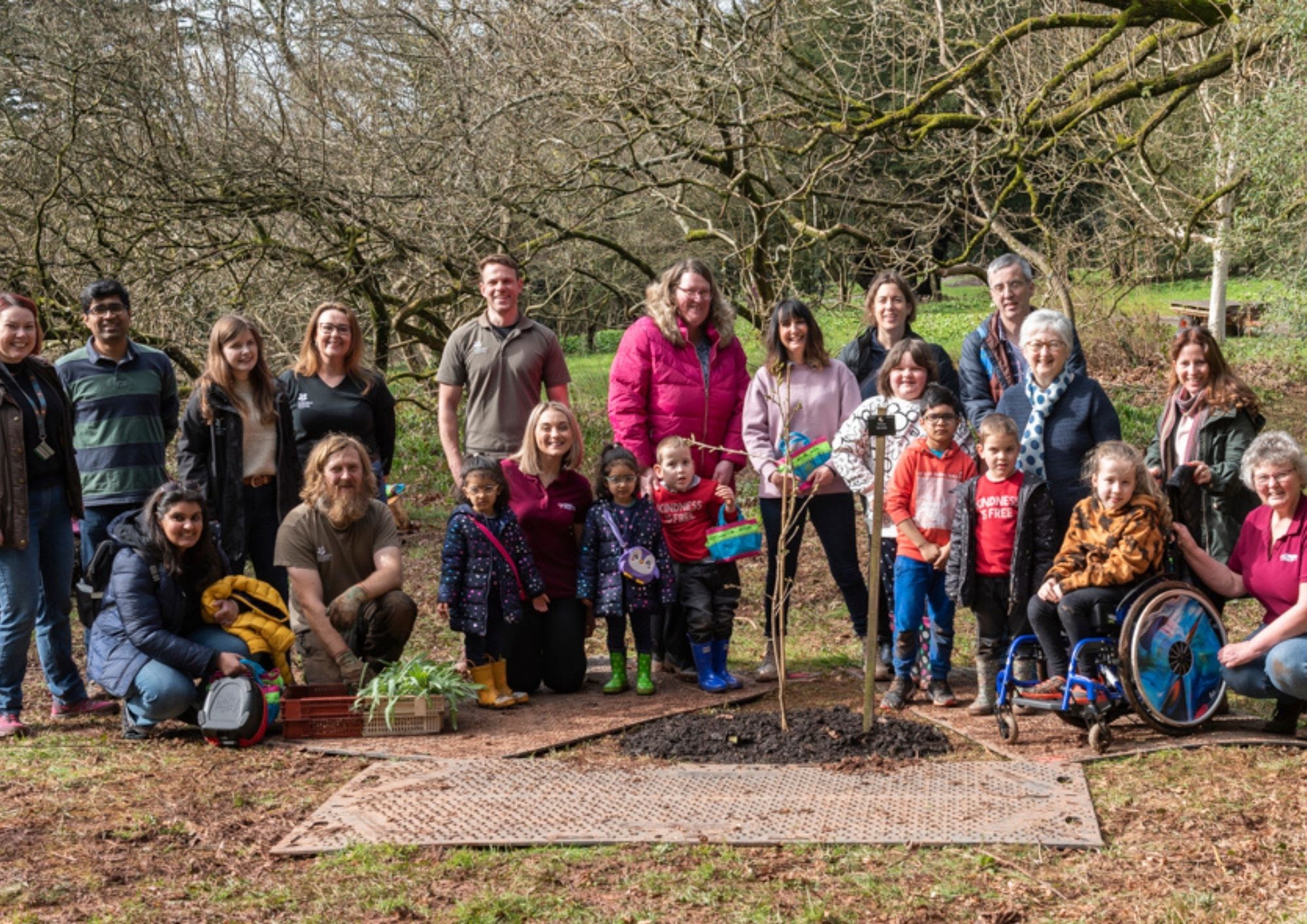 a group photo of families by a tree