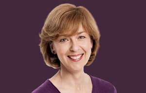 Ambassador head shot with purple background.