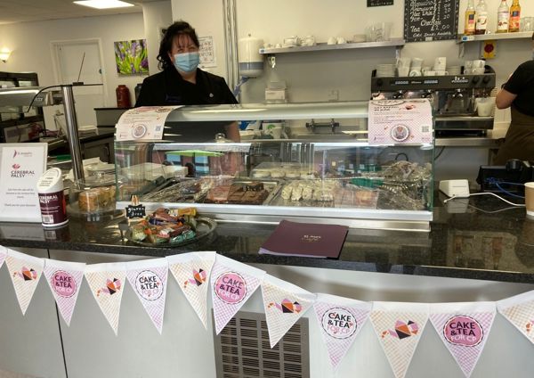 A woman in a canteen next to some cakes