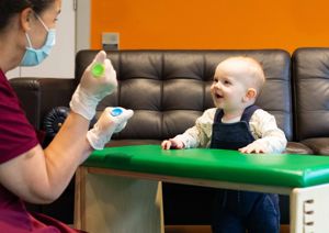 Photograph of baby looking up at therapist.