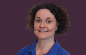 Therapist head shot with purple background.