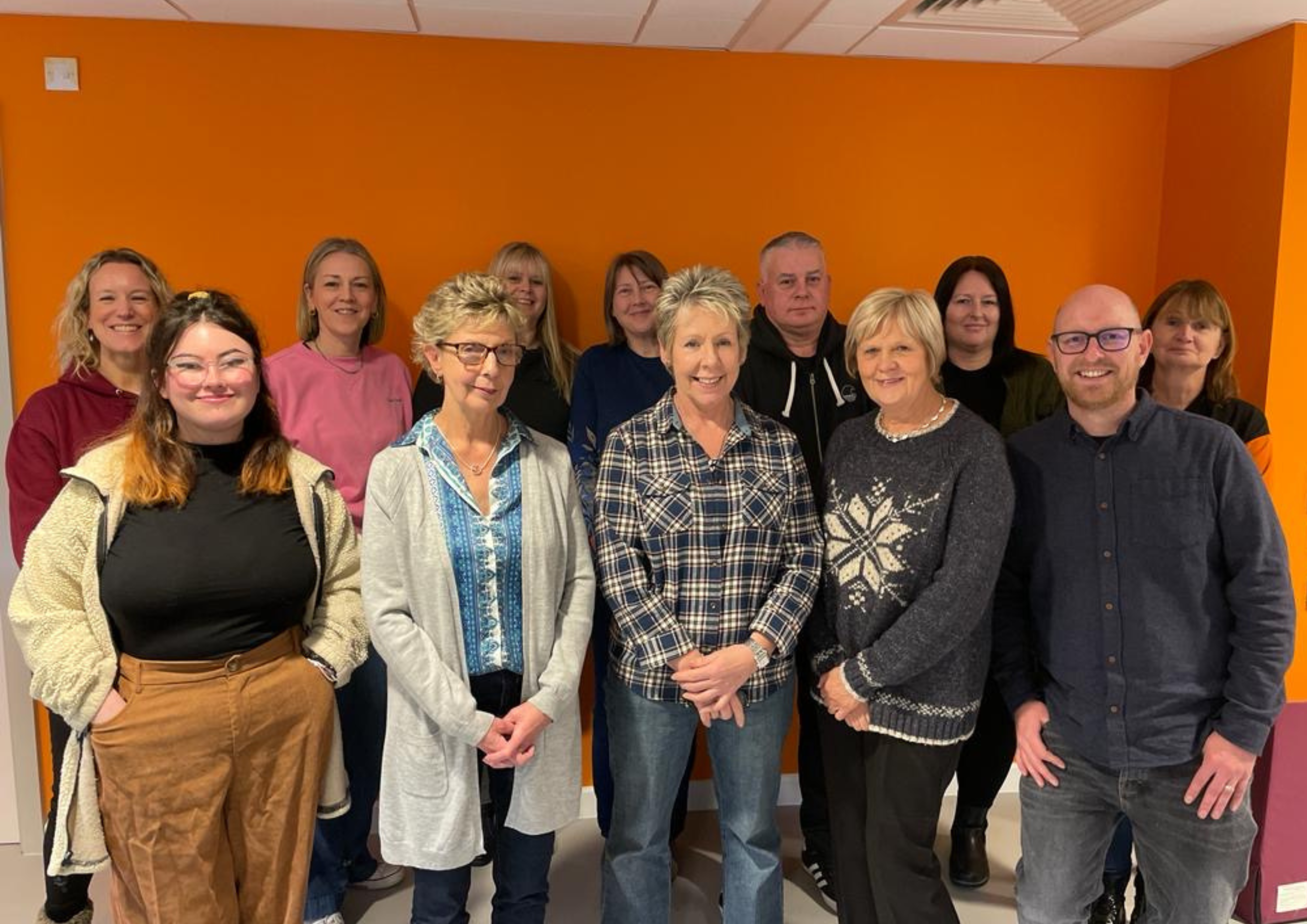 Photograph of our retail team standing together in one of our therapy rooms.