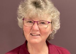 Photograph of one of our occupational therapists in front of purple wall.