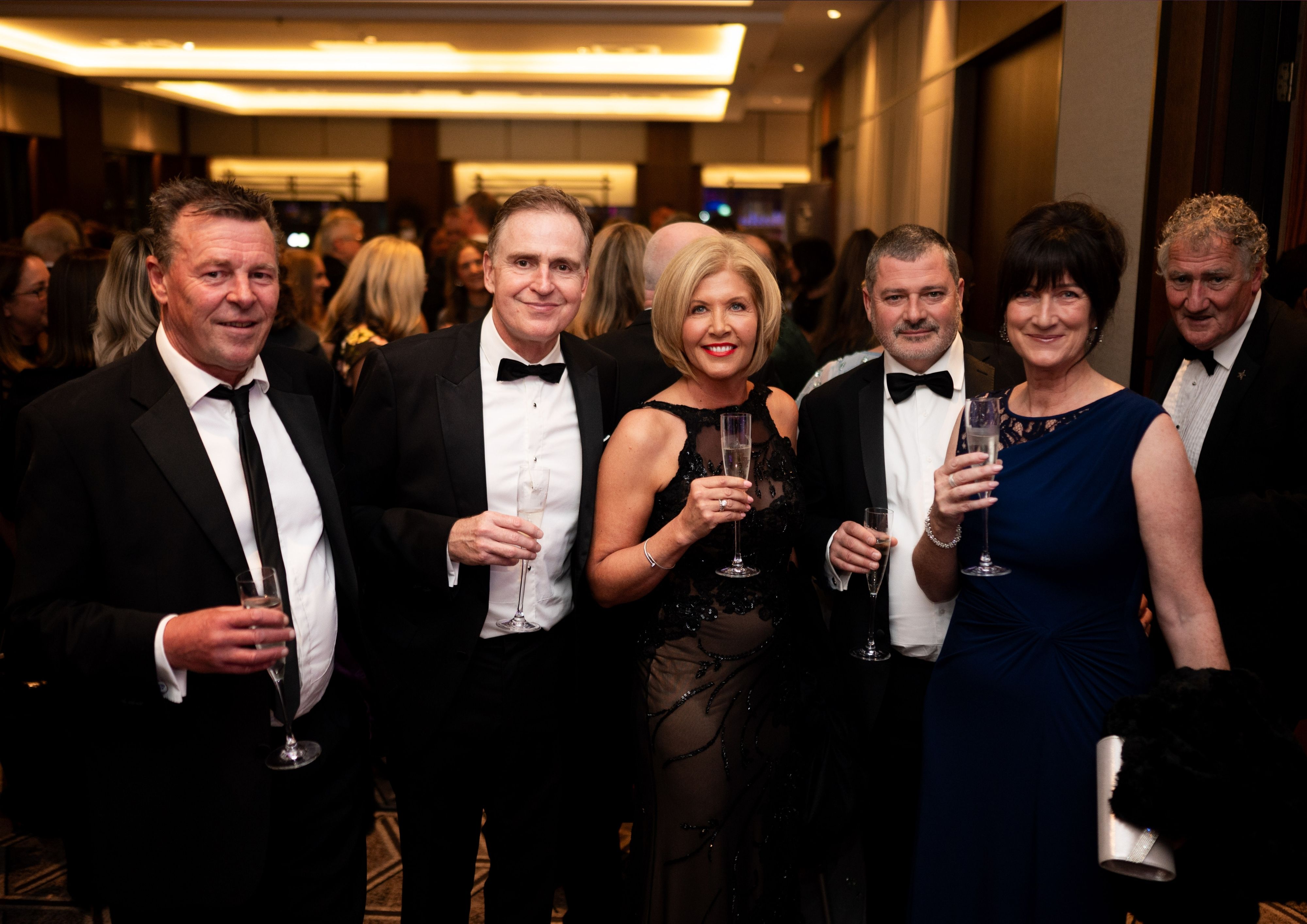 Group of men and women dressed in black tie at our Better Start Ball.