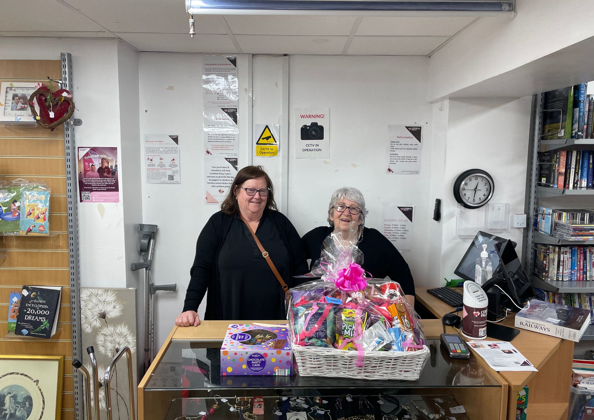 volunteers smile at camera with hamper