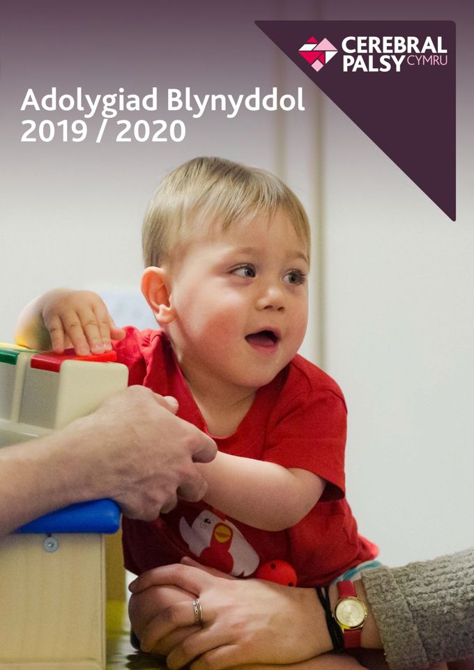 Screenshot of Welsh language annual review - reads Andolygiad Blynyddol 2019/2020. Photograph shows child holding toy, looking to the right.